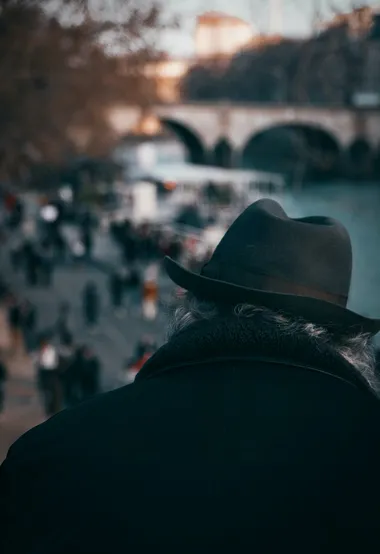 人来人往的街头，戴着黑帽穿着黑衣的老人背影图片