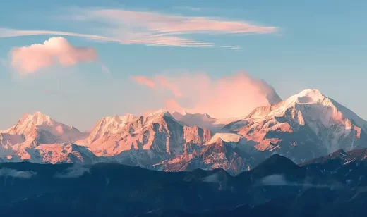 巍峨的雪山，在阳光照耀下，呈现出柔和的粉橙色，唯美壮丽桌面壁纸图片